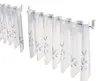 Two sets of cafe curtains with a blue floral pattern hanging on curtain rods. Produktbild-Vorschau