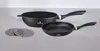 A set of cookware, including a large pan and a smaller frying pan, along with two circular trivets, are displayed on a light gray surface. Produktbild-Vorschau