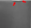 A close-up view of the top edge of a refrigerator, with two red arrows pointing to a slight indentation or imperfection. Produktbild-Vorschau