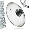 A glass pot lid with a black handle is shown on a white background, with a stack of other lids visible on the left and a product tag in the upper right corner. Náhľad obrázku produktu