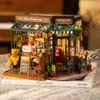 A miniature diorama of a bistro and restaurant, displayed on top of books. Voir les images du produit