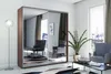 A modern bedroom with a large mirrored wardrobe, two armchairs, a coffee table, and a floor lamp. Náhled obrázku produktu