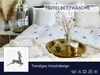 A neatly made bed with white hotel-style bedding featuring a subtle deer pattern, decorated with a golden tray holding a coffee and a small decorative item. Produktbild-Vorschau