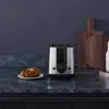 A toaster and a croissant on a kitchen counter. Náhľad obrázku produktu
