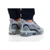 A pair of Nike Air Vapormax 2021 FK SE shoes worn by a person. Voir les images du produit
