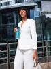 A woman in a white suit walks outside a modern building holding a teal thermos and a shopping bag. Produktbild-Vorschau