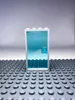 A LEGO door with a blue transparent panel and a white frame, placed on a grey LEGO baseplate. Náhled obrázku produktu