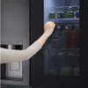 A hand opening a refrigerator door, revealing shelves stocked with food items. Produktbild-Vorschau