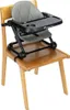 A baby high chair booster seat is attached to a wooden chair. Voir les images du produit
