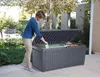 A woman is putting items into a large outdoor storage box. Produktbild-Vorschau