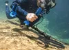 A diver using a metal detector underwater. Produktbild-Vorschau