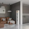 A modern living room with a brown leather sectional sofa, a white bookshelf, and a glimpse of a kitchen in the background. Produktbild-Vorschau