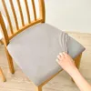 A hand is shown adjusting a beige seat cover on a wooden chair. Anteprima dell’immagine prodotto