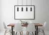 A dining table with chairs and a blank picture frame on the wall, with pendant lights above. Náhled obrázku produktu