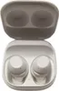 A pair of white wireless earbuds in their charging case. Voir les images du produit