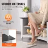 A woman is sitting on a shoe rack, adjusting her shoe. The shoe rack is white with black shelves and has shoes on its shelves. Podgląd zdjęcia produktu