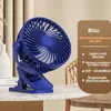 A blue clip-on fan is placed on a table, with informational text in German on the right side. Produktbild-Vorschau