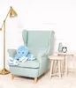 A blue plush octopus sits on a light blue armchair next to a small side table with a vase and an alarm clock. Produktbild-Vorschau