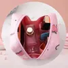 Rosa Kosmetiktasche mit Pfirsich-Illustrationen, offen, mit Parfümflasche und anderen Kosmetika im Inneren Náhľad obrázku produktu