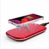 A smartphone is being wirelessly charged by a red charging pad. Produktbild-Vorschau