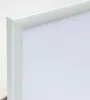 A close-up view of the corner of a white picture frame with a white matting inside. Produktbild-Vorschau