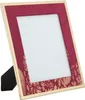 A close-up, angled view of a burgundy photo frame with a gold floral pattern and a gold trim, set against a white background. Náhľad obrázku produktu