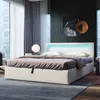 A modern bedroom with a white bed frame featuring LED lighting, a grey rug, and large windows with sheer curtains. Náhled obrázku produktu