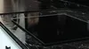 A close-up shot of a black glass stovetop protector on a kitchen counter. Anteprima dell’immagine prodotto