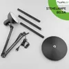 The image shows the disassembled parts of a black floor lamp, including the base, adjustable arm, and pole sections, laid out on a light gray surface. Produktbild-Vorschau