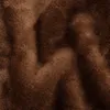 A close-up view of brown, plush fabric with visible texture and folds. Anteprima dell’immagine prodotto