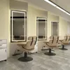 A row of barber chairs and illuminated mirrors in a salon. Produktbild-Vorschau