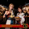 Two women in traditional Japanese attire holding bowls of ramen and stew in an outdoor market setting. Produktbild-Vorschau