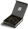 A black gift box with the lid open, revealing a coiled necklace with a cross pendant inside. Podgląd zdjęcia produktu