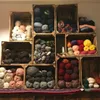 A collection of wooden crates filled with various types of yarn. Produktbild-Vorschau