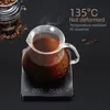 A coffee carafe filled with coffee sits on a digital scale, with coffee beans and a coffee container in the background. Náhled obrázku produktu