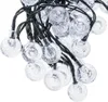 A close-up view of a string of solar garden lights with clear, round bulbs containing glitter. Náhľad obrázku produktu