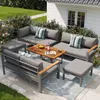A modern outdoor lounge set is arranged on a patio with a white building and garden in the background. Voir les images du produit