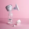 A breast pump and bottle are displayed on a pink surface. Podgląd zdjęcia produktu