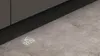 A close-up shot of a dishwasher's projected display on a concrete floor. Produktbild-Vorschau