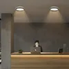 A woman is working at a reception desk with a laptop, illuminated by ceiling lights. Náhľad obrázku produktu