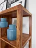 A close-up view of a wooden bookshelf with two blue vases on it. Podgląd zdjęcia produktu