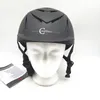 A gray equestrian helmet is displayed on a white mannequin head against a white background. A small instruction booklet is visible to the left of the helmet. Produktbild-Vorschau