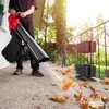 A person is using a leaf blower on a patio with fallen leaves. Produktbild-Vorschau