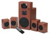 A 5.1 speaker system with a wooden finish, including a subwoofer and satellite speakers, along with a remote control. Produktbild-Vorschau