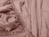 A close-up view of a wrinkled, apricot-colored fitted sheet, showing the elasticized edge. Produktbild-Vorschau