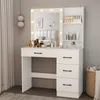 A white vanity table with a lighted mirror, drawers, and shelves, set in a bedroom with curtains and a basket. Voir les images du produit