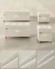 Four beige storage ottomans of varying sizes are displayed on a light gray floor. Below the ottomans, three close-up images of the fabric texture are shown. Produktbild-Vorschau