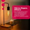 A close-up of a vintage-style LED lamp with a lit candle on a wooden surface. Produktbild-Vorschau