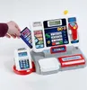 A hand inserts a credit card into a toy cash register. Produktbild-Vorschau