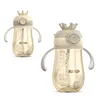 Two baby bottles with crowns on top, shown against a white background. Produktbild-Vorschau